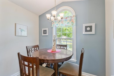 Dining room featuring lofted ceiling, a chandelier, and baseboards