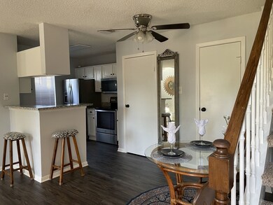 Another view of dining/kitchen area featuring half