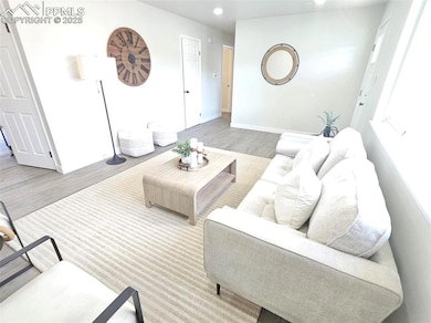 Living room featuring wood finished floors, basebo