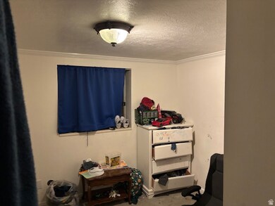Bedroom featuring a textured ceiling and crown molding