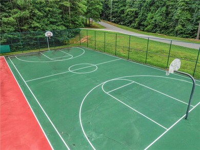 View of sport court with a wooded view and community basketball court