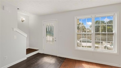 Entrance foyer featuring baseboards, dark wood-sty