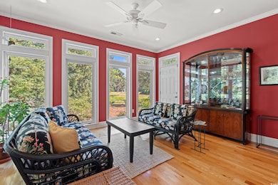 Sunroom featuring wood finished floors, healthy amount of natural light, recessed lighting, and crown molding