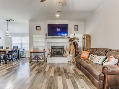 Living room with crown molding, ceiling fan, a fir