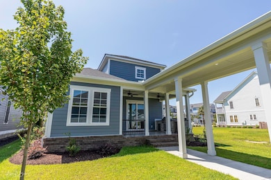 View of front of home featuring a ceiling fan, a porch, and a front yard