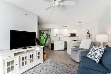 Living area featuring wood finished floors, ceiling fan, and arched walkways