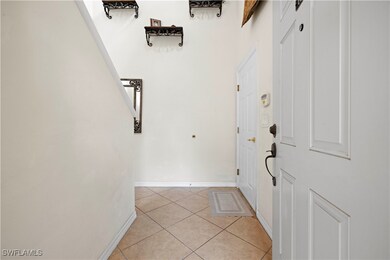 Foyer with baseboards and light tile patterned flo