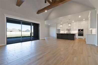 Unfurnished living room featuring beam ceiling, li