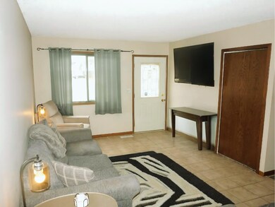 6639 84th - Living Room on main level. Featuring tile flooring and ample sunlight. Television mount included in the sale of the property.