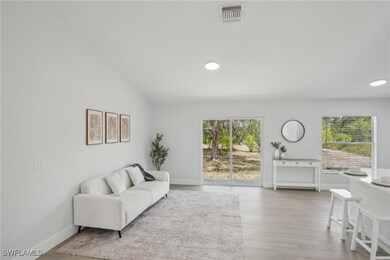 Living room featuring visible vents, vaulted ceili