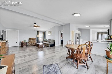 Dining room with light wood-type flooring, a ceiling fan, and baseboards
