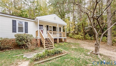 View of front of property with a porch, stairs, and view of scattered trees