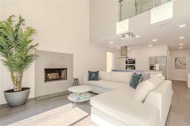 Living room with a fireplace, baseboards, and light wood-type flooring