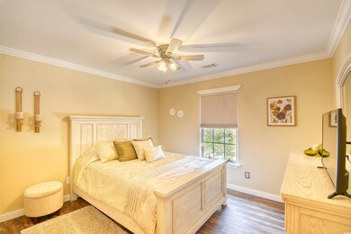Bedroom featuring crown molding, dark wood-type fl