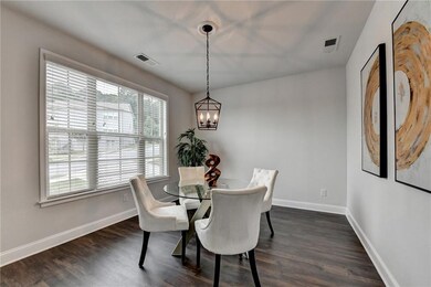 Dining area featuring a chandelier and dark wood-type flooring
