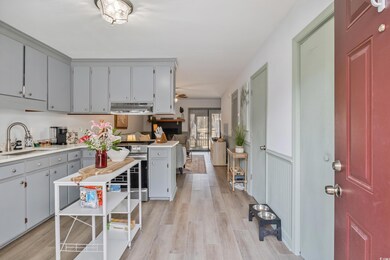 Kitchen with light wood finished floors, light cou
