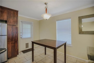 Dining room with ornamental molding, healthy amount of natural light, and baseboards