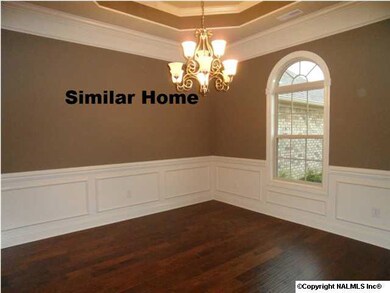 Dining room with 10 foot ceiling, trey ceiling, chair rail and shadow boxes, wood flooring.