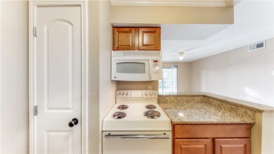Kitchen featuring a peninsula, white appliances, v