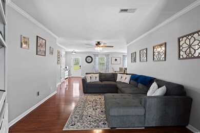 Living room with ceiling fan, dark wood-style floo