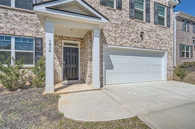 Doorway to property with brick siding, driveway, a