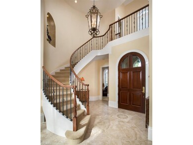 Large custom door and grand staircase to the second floor