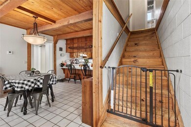 Dining area featuring wooden ceiling with exposed beams, stairway, and light tile patterned flooring