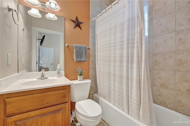 Bathroom featuring shower / tub combo, vanity, and toilet