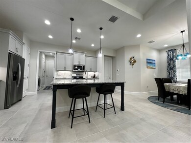 Kitchen featuring fridge, an island with sink, gra