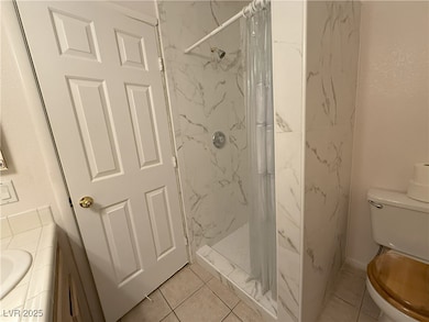 Featuring step in shower, toilet, vanity, a marble
