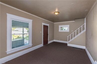 Carpeted entrance foyer featuring ornamental moldi