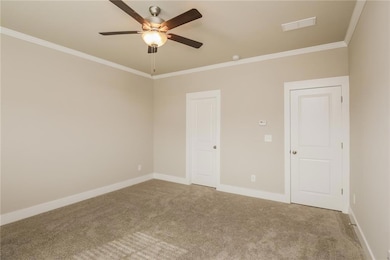 Spare room with carpet floors, a ceiling fan, and 