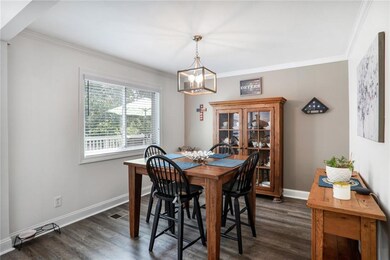 Dining area featuring a chandelier, crown molding, and dark wood-style floors