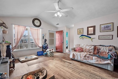 Living room with lofted ceiling, ceiling fan, and 