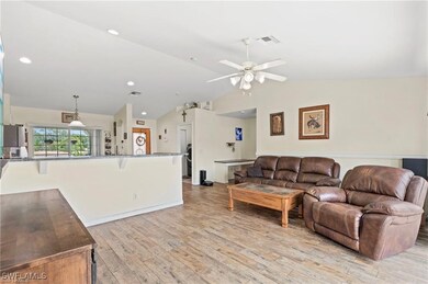 Living area with vaulted ceiling, light wood finished floors, ceiling fan, and recessed lighting