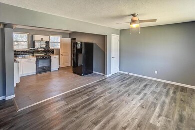 Kitchen with hardwood / wood-style flooring, white cabinetry, black appliances, backsplash, and ceiling fan