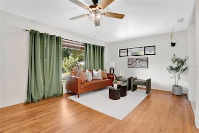 Natural light pours in, highlighting the hardwood floors and the warmth that fills this inviting living space.