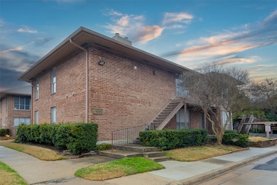 Property exterior at dusk with stairs, brick siding, and a chimney