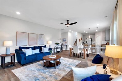 Living room featuring visible vents, a ceiling fan