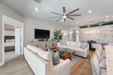 Living area with ceiling fan, light wood-style flo