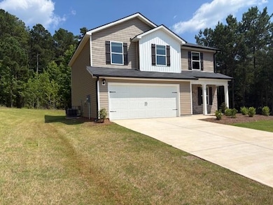 View of front facade featuring a garage, driveway, a front yard, and board and batten siding