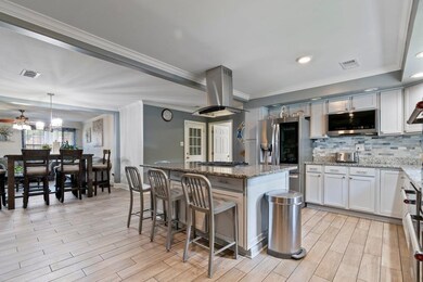 Kitchen with ceiling fan, a kitchen bar, a center 