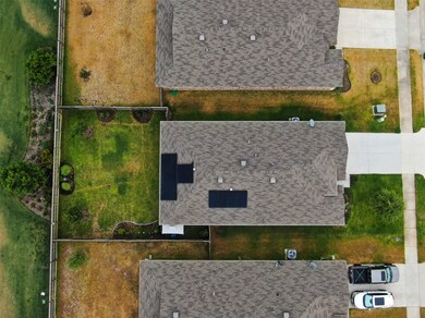 Aerial view of the home showing solar panels. No neighbors behind and 1-stories on both sides.