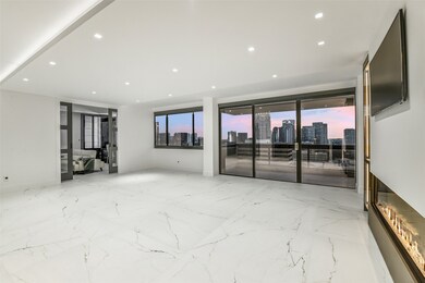 From this angle, the open living area showcases expansive glass doors that lead to the balcony, filling the space with natural light and extending the living area outdoors. The layout flows effortlessly toward the flex room, offering a seamless connection between indoor comfort and versatile functionality.