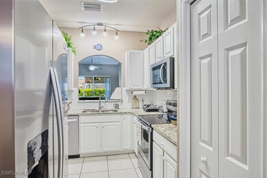 Kitchen with a sink, white cabinetry, a ceiling fa