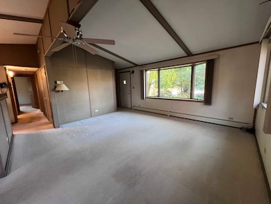 Unfurnished living room with carpet flooring, baseboard heating, and ceiling fan