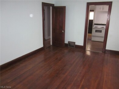 Unfurnished bedroom featuring dark hardwood / wood-style flooring