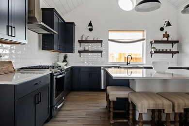 Kitchen with island, pendant lighting and open shelving