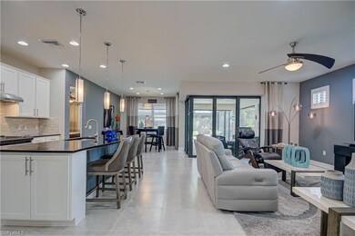 Open living room & dining for entertaining-  with recessed lighting, a ceiling fan, and light tile patterned floors. Zero edge doors make indoor/outdoor flow easy