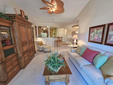 Living room with light carpet, lofted ceiling, and ceiling fan